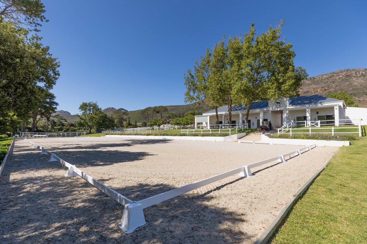 Another angle of the dressage arena showing the full facility with mountains