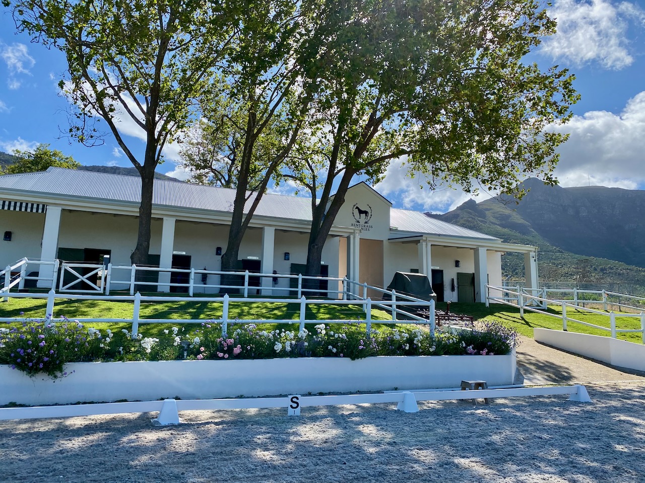 Stable building from arena perspective with dramatic mountain backdrop